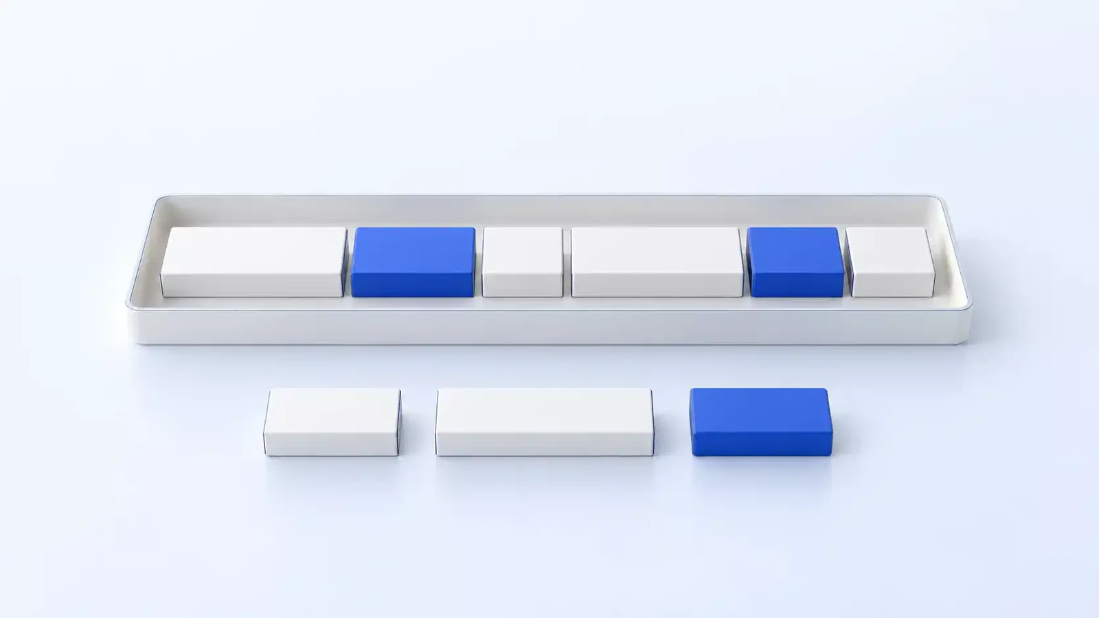 A shallow tray holding a row of blocks that fit exactly, two of them blue, with three more blocks set calmly to one side because there was no room for them.