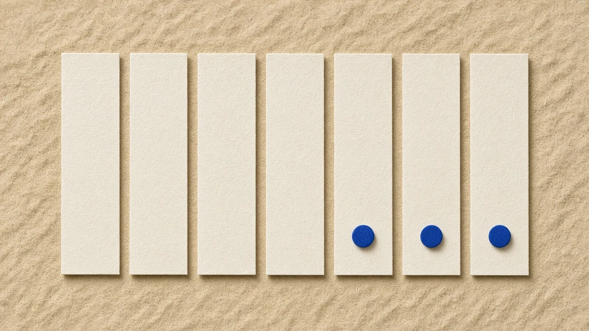 Seven paper strips laid out like a week, with three small blue markers on the final three strips.